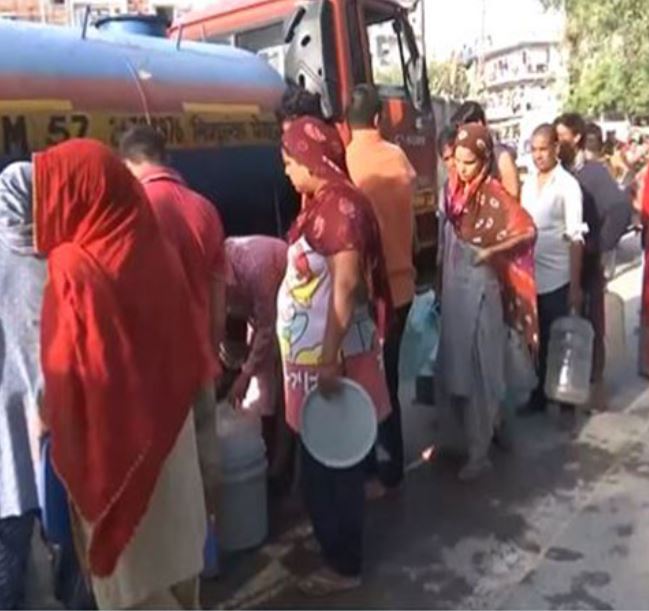 People standing in queue to collect water